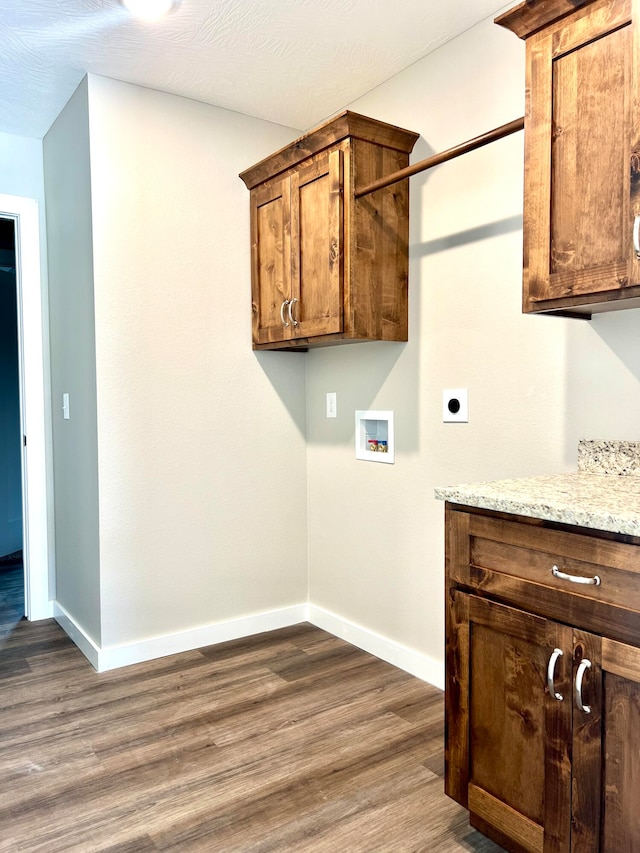 laundry area with cabinets, hookup for a washing machine, electric dryer hookup, dark hardwood / wood-style floors, and a textured ceiling