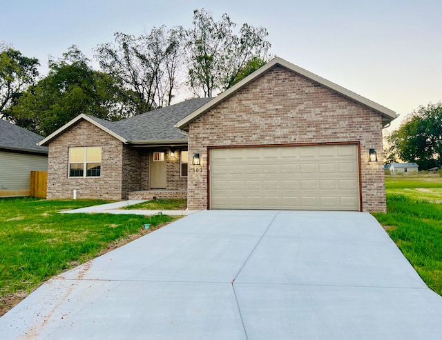 view of front of property with a garage and a yard