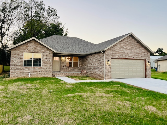 view of front of house with a garage and a yard