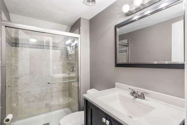 full bath with visible vents, a shower stall, toilet, and vanity