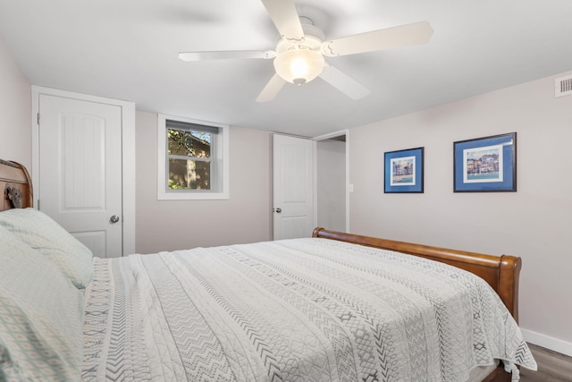 bedroom with a ceiling fan, baseboards, and wood finished floors