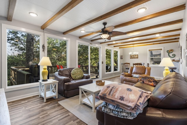 living area with beam ceiling, baseboards, wood finished floors, and ceiling fan with notable chandelier