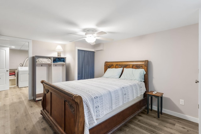 bedroom featuring baseboards, a ceiling fan, light wood-style flooring, and washer / clothes dryer