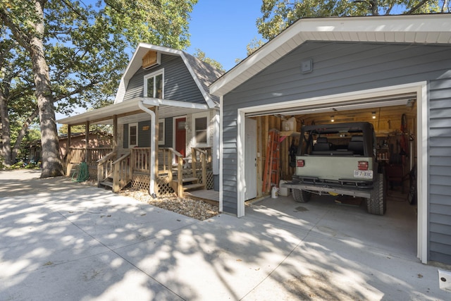 view of home's exterior with driveway, a porch, and a gambrel roof