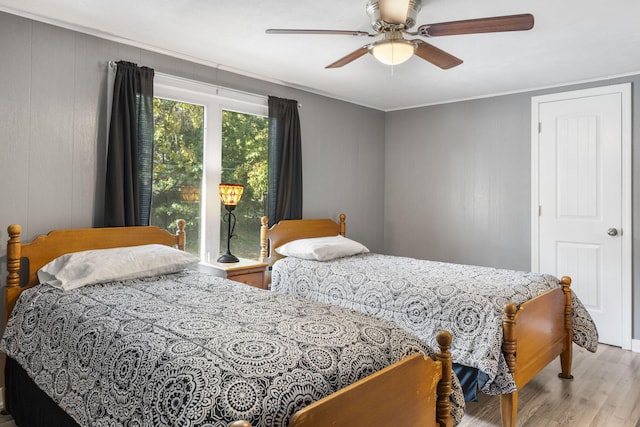 bedroom featuring light wood finished floors, ceiling fan, and ornamental molding