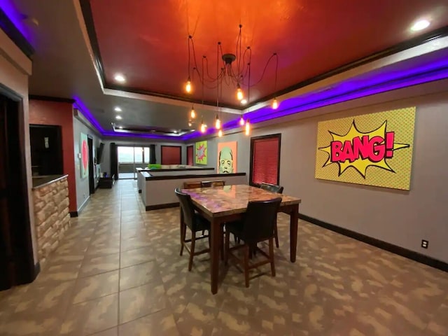 dining space with a tray ceiling, a chandelier, ornamental molding, and tile patterned flooring