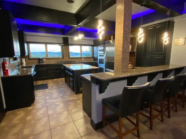 kitchen with light stone counters, kitchen peninsula, hanging light fixtures, a breakfast bar area, and appliances with stainless steel finishes