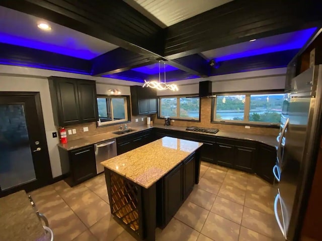 kitchen with a kitchen island, stainless steel appliances, sink, pendant lighting, and beam ceiling