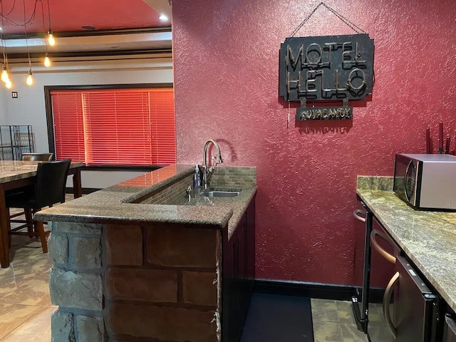 kitchen featuring stone countertops and sink