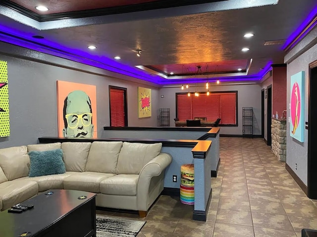 home theater with ornamental molding, tile patterned floors, and a raised ceiling