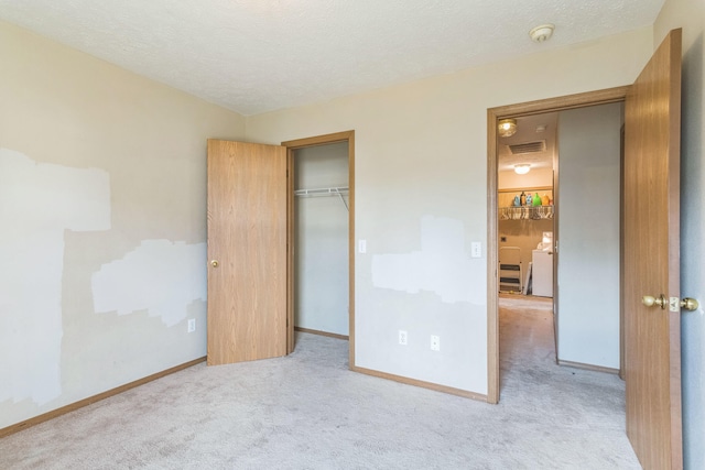 unfurnished bedroom featuring light colored carpet, a closet, and a textured ceiling