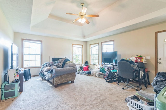 carpeted bedroom featuring ceiling fan, a textured ceiling, and a tray ceiling