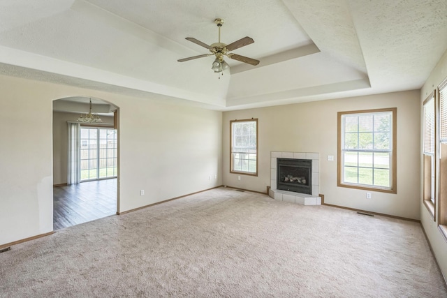 1006 Care Ave, Nixa, MO 65714 - unfurnished living room featuring carpet flooring, a raised ceiling, arched walkways, and baseboards