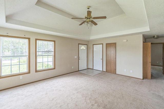 1006 Care Ave, Nixa, MO 65714 - unfurnished living room with a tray ceiling, carpet, a ceiling fan, and baseboards