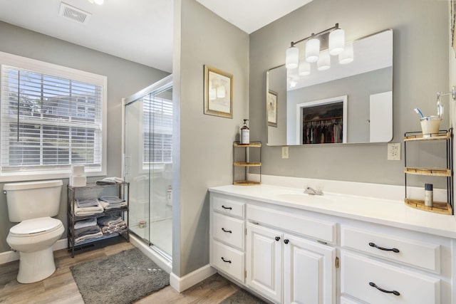 bathroom with walk in shower, hardwood / wood-style floors, vanity, and toilet