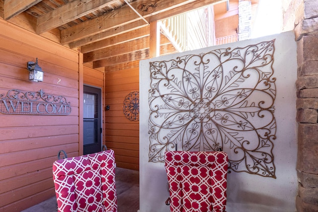 bathroom featuring wooden walls and beam ceiling