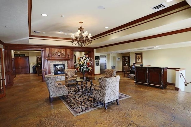 living room featuring a tray ceiling, crown molding, a chandelier, and a stone fireplace