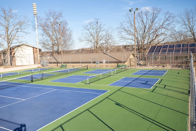 view of sport court with basketball hoop and a shed