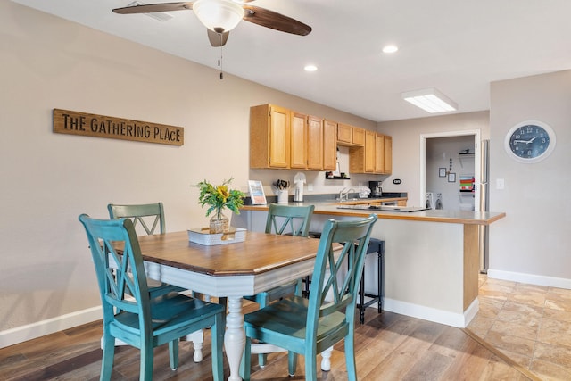 dining space with ceiling fan and light hardwood / wood-style floors