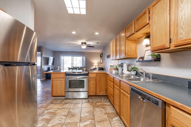 kitchen with ceiling fan, sink, stainless steel appliances, and kitchen peninsula