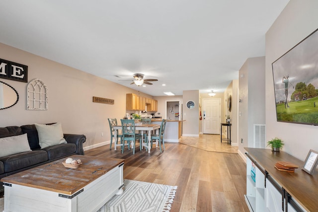 living room with light hardwood / wood-style floors and ceiling fan