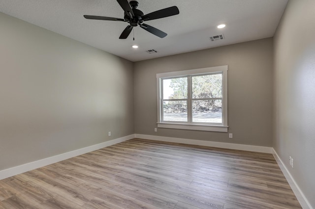 empty room with light hardwood / wood-style floors, a textured ceiling, and ceiling fan