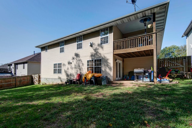 rear view of house featuring a lawn, a balcony, and a patio area