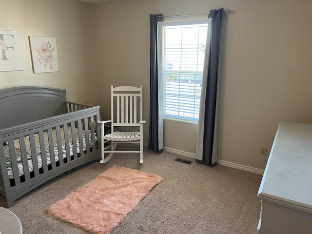 bedroom with a crib and carpet floors