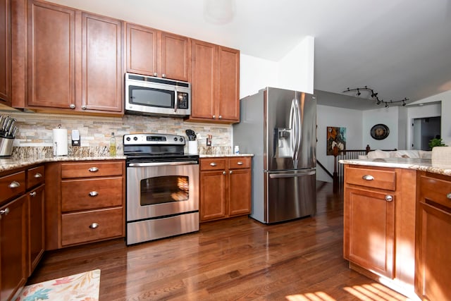 kitchen with dark hardwood / wood-style floors, light stone countertops, backsplash, and appliances with stainless steel finishes