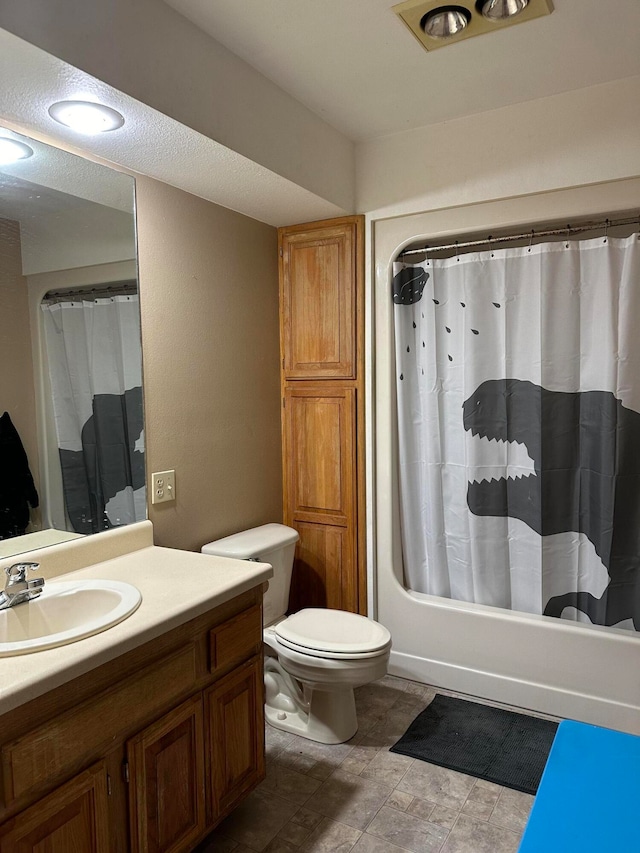 full bathroom with vanity, shower / tub combo with curtain, and toilet