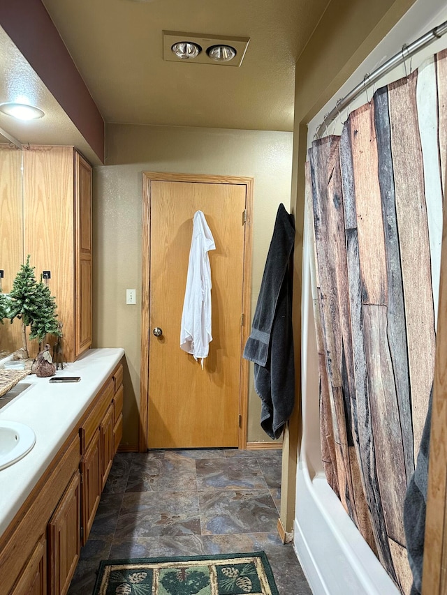 bathroom featuring shower / bath combo and vanity