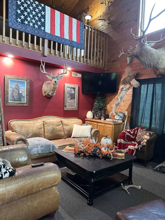 carpeted living room featuring a high ceiling and wood ceiling