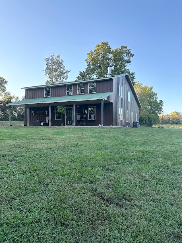 rear view of house featuring a lawn