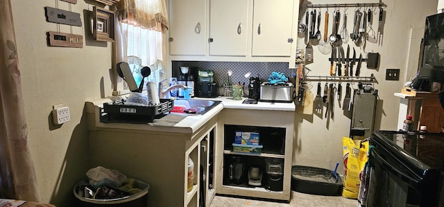 kitchen featuring decorative backsplash, white cabinetry, and sink