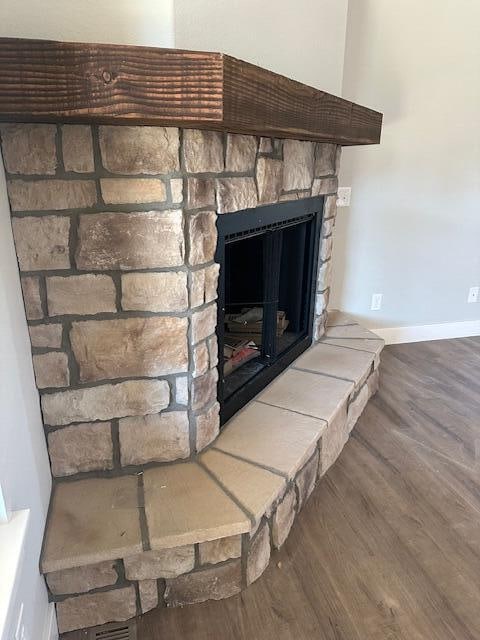 details featuring a stone fireplace and hardwood / wood-style flooring