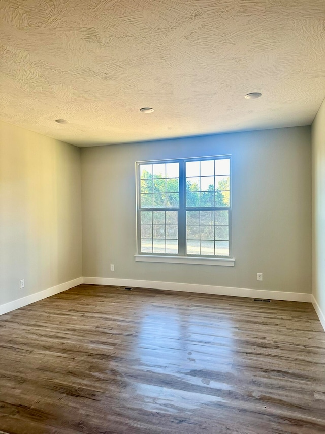 spare room with wood-type flooring and a textured ceiling