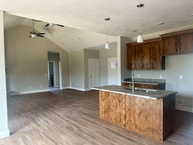 kitchen featuring sink, decorative light fixtures, and dark wood-type flooring