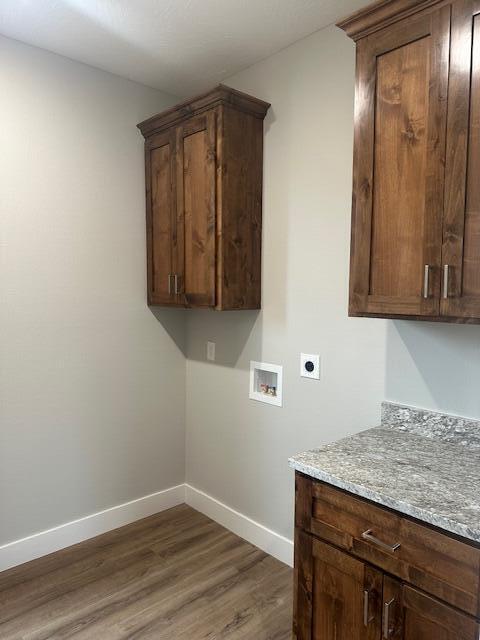 laundry room with cabinets, hookup for a washing machine, dark wood-type flooring, and hookup for an electric dryer