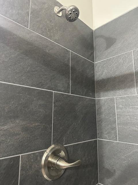 interior details with a tile shower