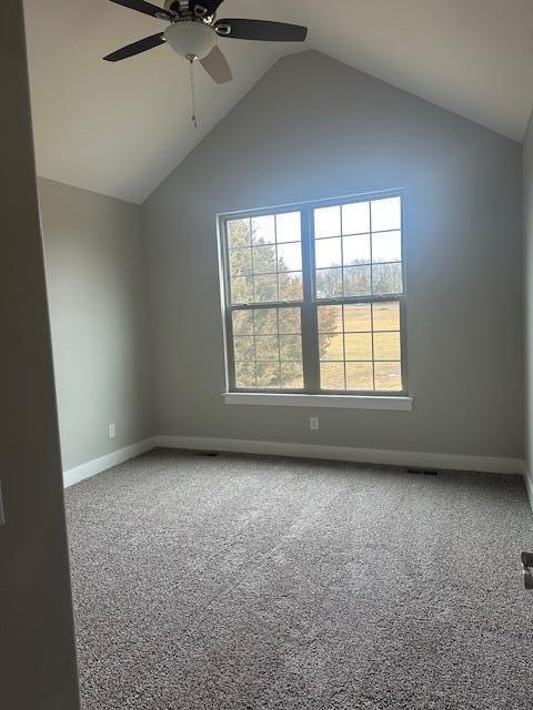 carpeted empty room with high vaulted ceiling and ceiling fan