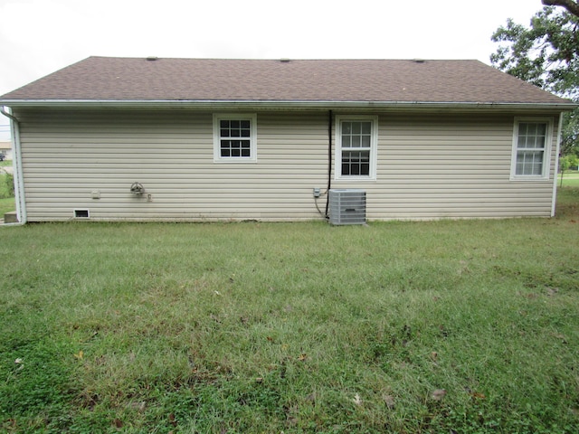 back of house featuring central AC and a lawn