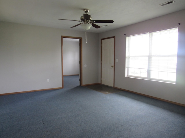 carpeted spare room with ceiling fan