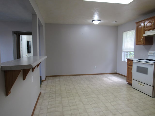 kitchen featuring white range with electric stovetop, a kitchen bar, and custom exhaust hood