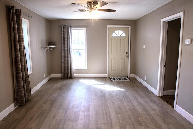entryway with ceiling fan, baseboards, and wood finished floors