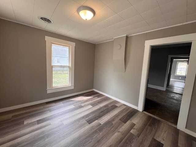 unfurnished room featuring dark hardwood / wood-style floors and a healthy amount of sunlight