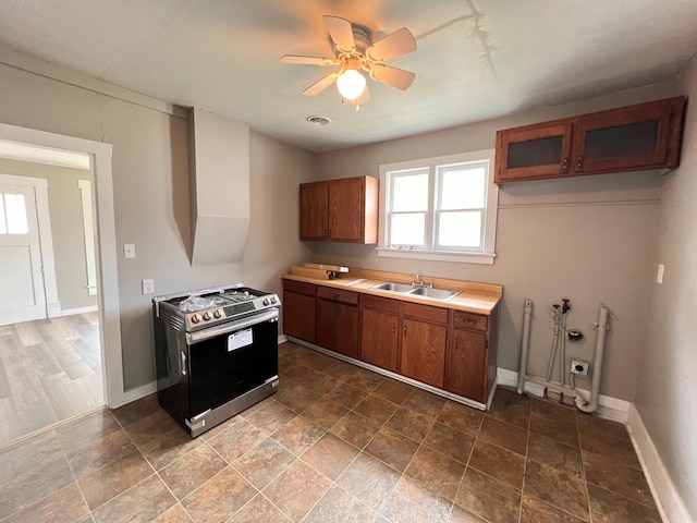 kitchen featuring stainless steel range, sink, and ceiling fan