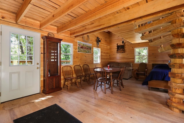 dining space with wooden ceiling, light hardwood / wood-style floors, beamed ceiling, and a healthy amount of sunlight