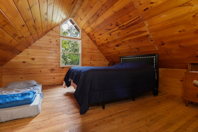 bedroom with wood walls, light hardwood / wood-style floors, wood ceiling, and lofted ceiling