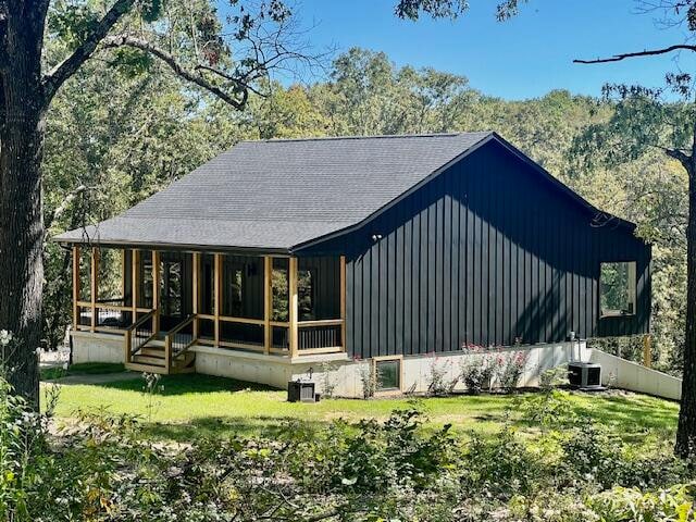 back of house featuring a yard and central air condition unit