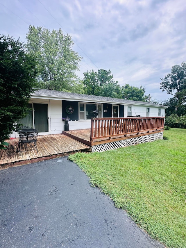 view of front of home featuring a front yard and a deck